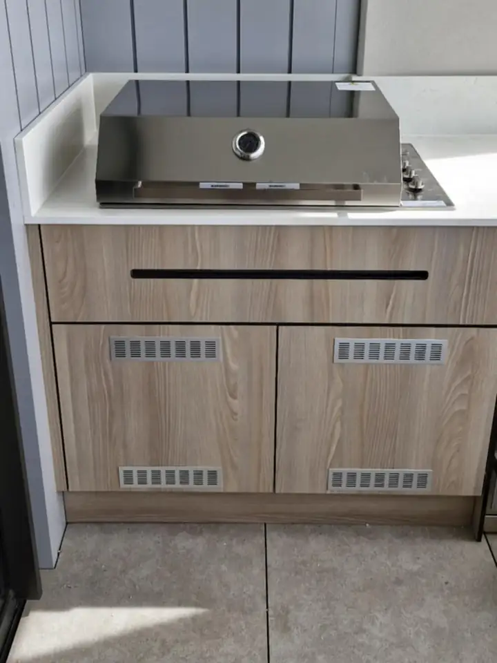 An outdoor kitchen bench with a built-in barbecue