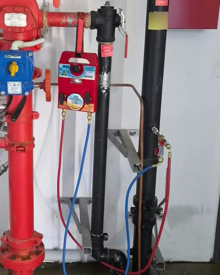 A sprinkler valve set with a blue flow meter hose connected