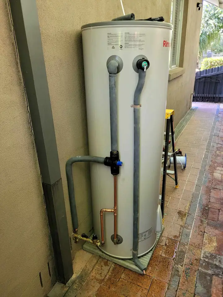 An electric storage hot water unit down the side of a house