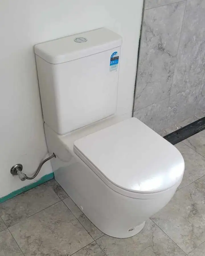 A back-to-wall toilet against marble-look tiles